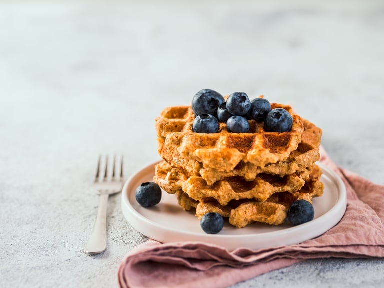 Stack of healthy gluten free protein waffles with blueberries on a plate
