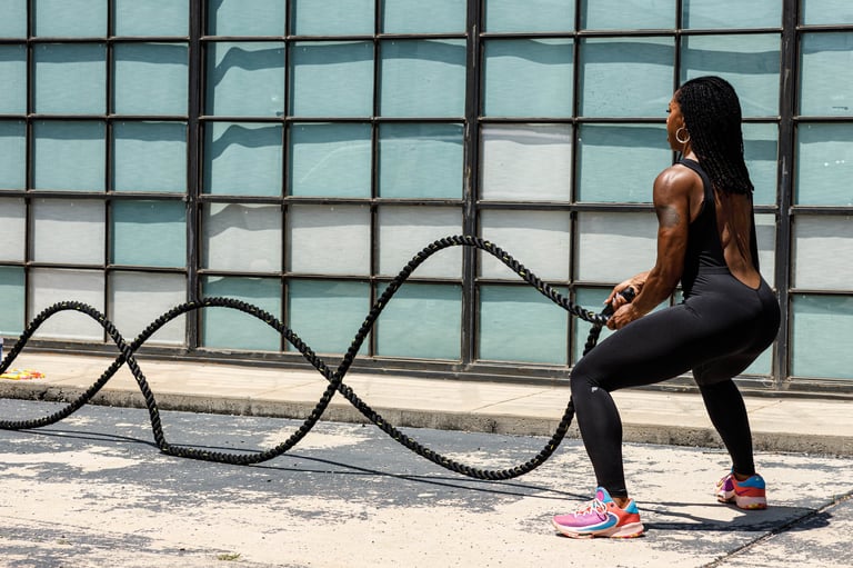 Woman exercising with battle ropes during outdoor fitness training